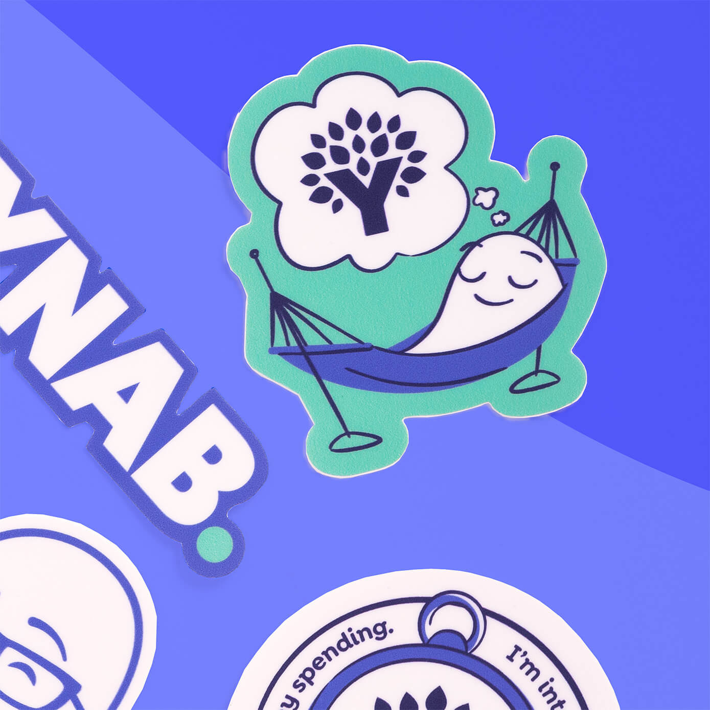 YNAB sticker featuring a relaxed figure in a hammock dreaming of the YNAB logo, shown on a blue background with other YNAB stickers.