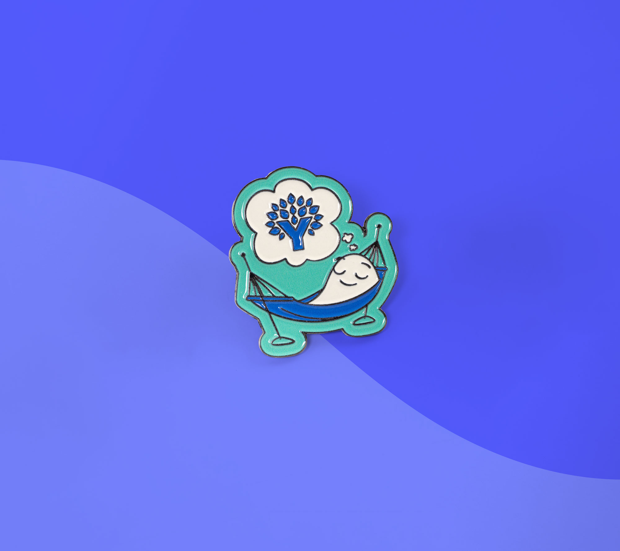 YNAB enamel pin shaped like a relaxed character in a hammock dreaming of the YNAB logo, displayed on a blue background.
