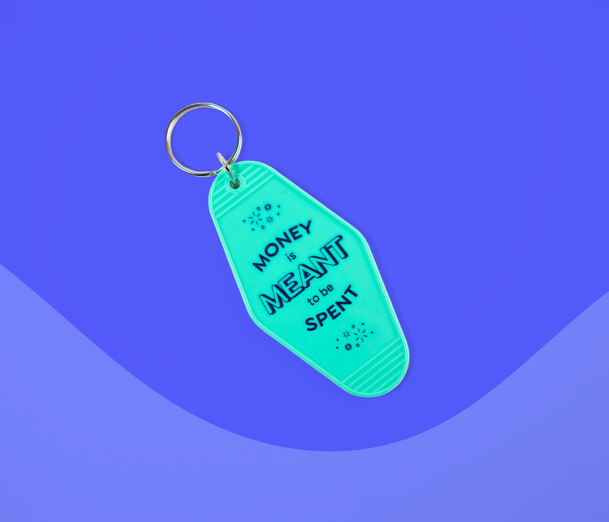 YNAB keychain that reads “Money is meant to be spent” displayed on a blue background.