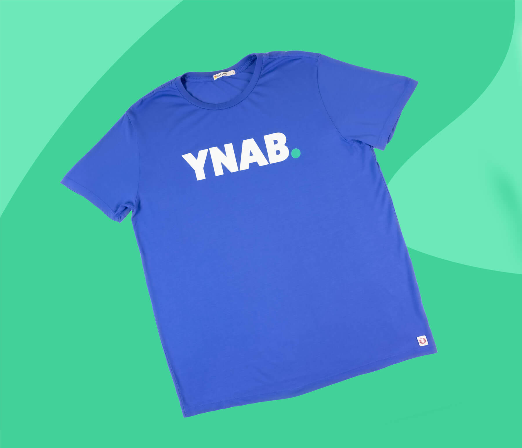 YNAB blue “Blurple” t-shirt featuring the white YNAB logo and teal dot, displayed on a light teal background.
