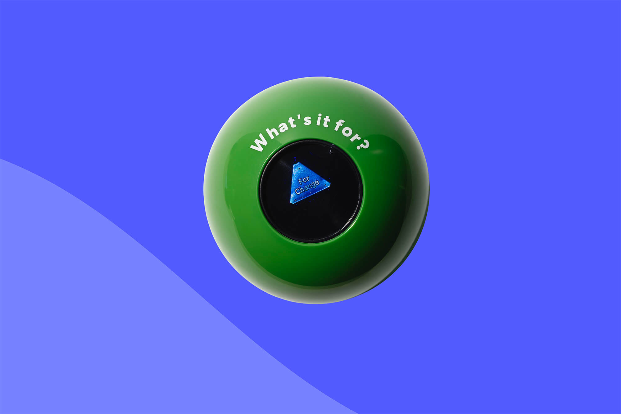 A bright green 8-ball  with the text 'What's it for?' printed in white around the answer window containing a small blue triangle with the words For Change, photographed on a blue background with a soft shadow.