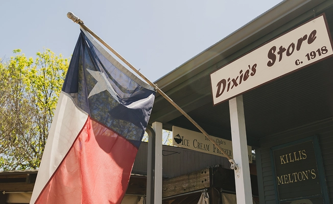 Early 1900s storefront with a Texas flag.