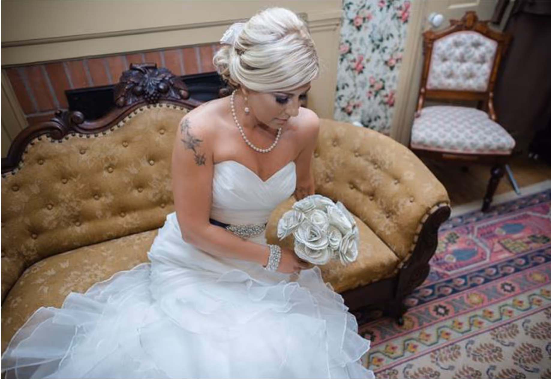 Bride inside in a reflective pose holding a bouquet 