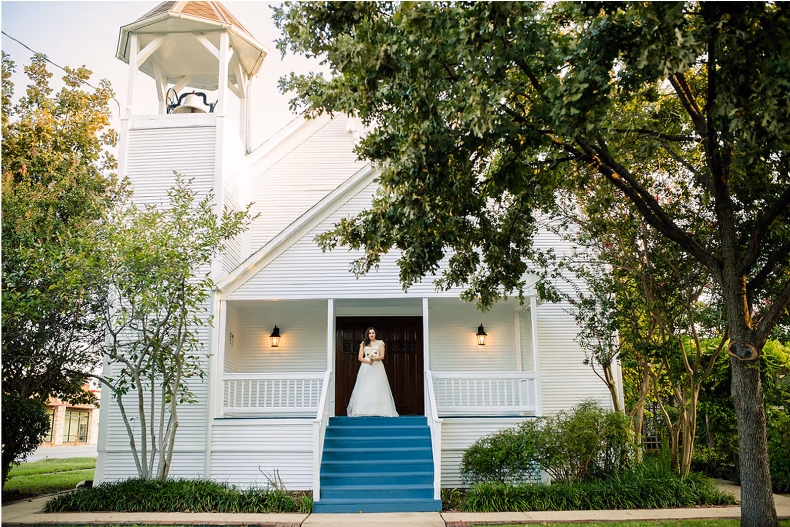 Smiling bride in front of historic chapel