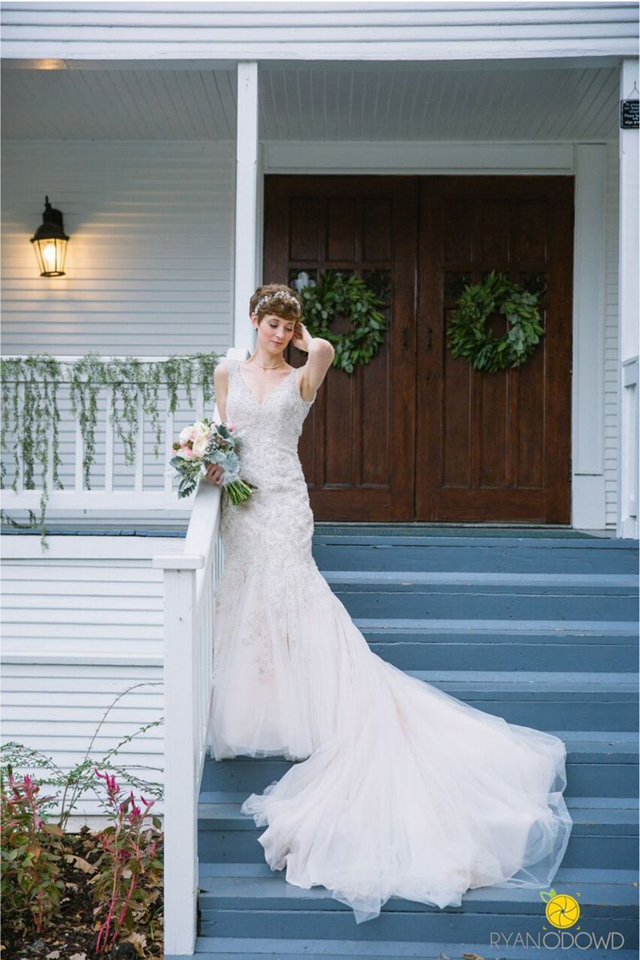 A bride poses on the steps of the wedding chapel