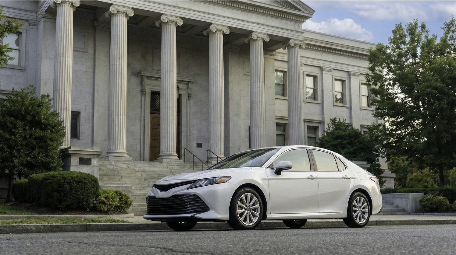 Vehicle tracking legal compliance concept with company sedan parked outside courthouse building representing employer GPS tracking laws in the United States