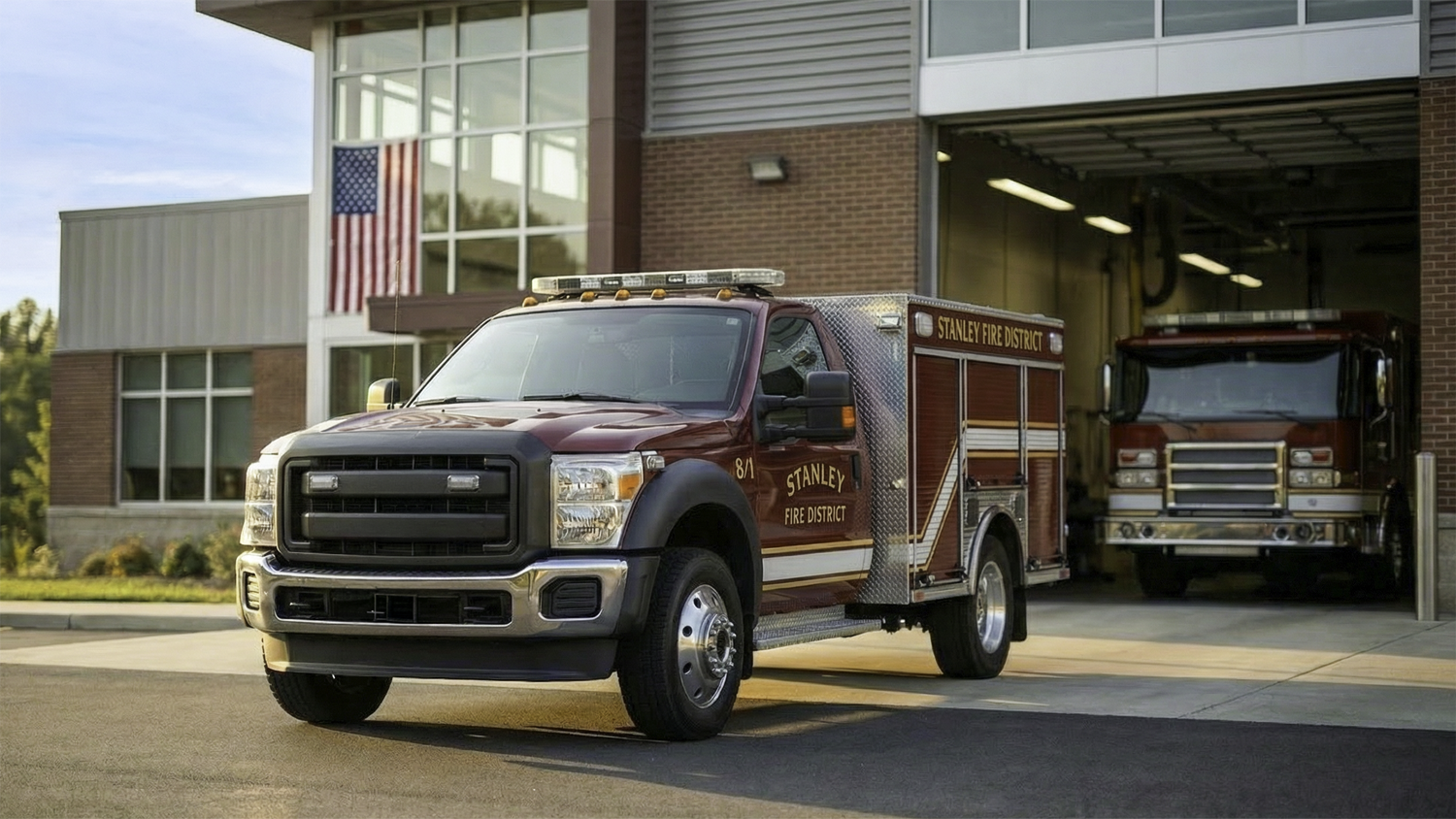 Fire department support vehicle parked outside a fire station bay representing fleet management for fire departments