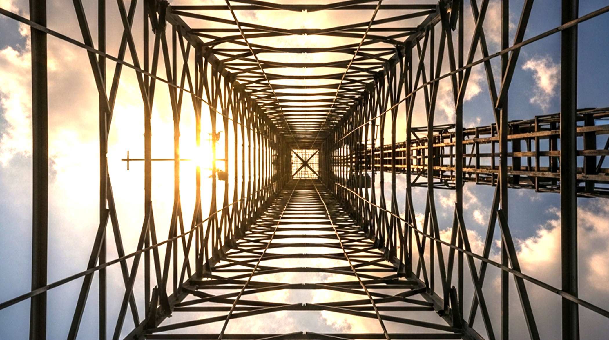 Upward view through a cellular tower framework, illustrating the 4G LTE network coverage behind Bouncie GPS trackers