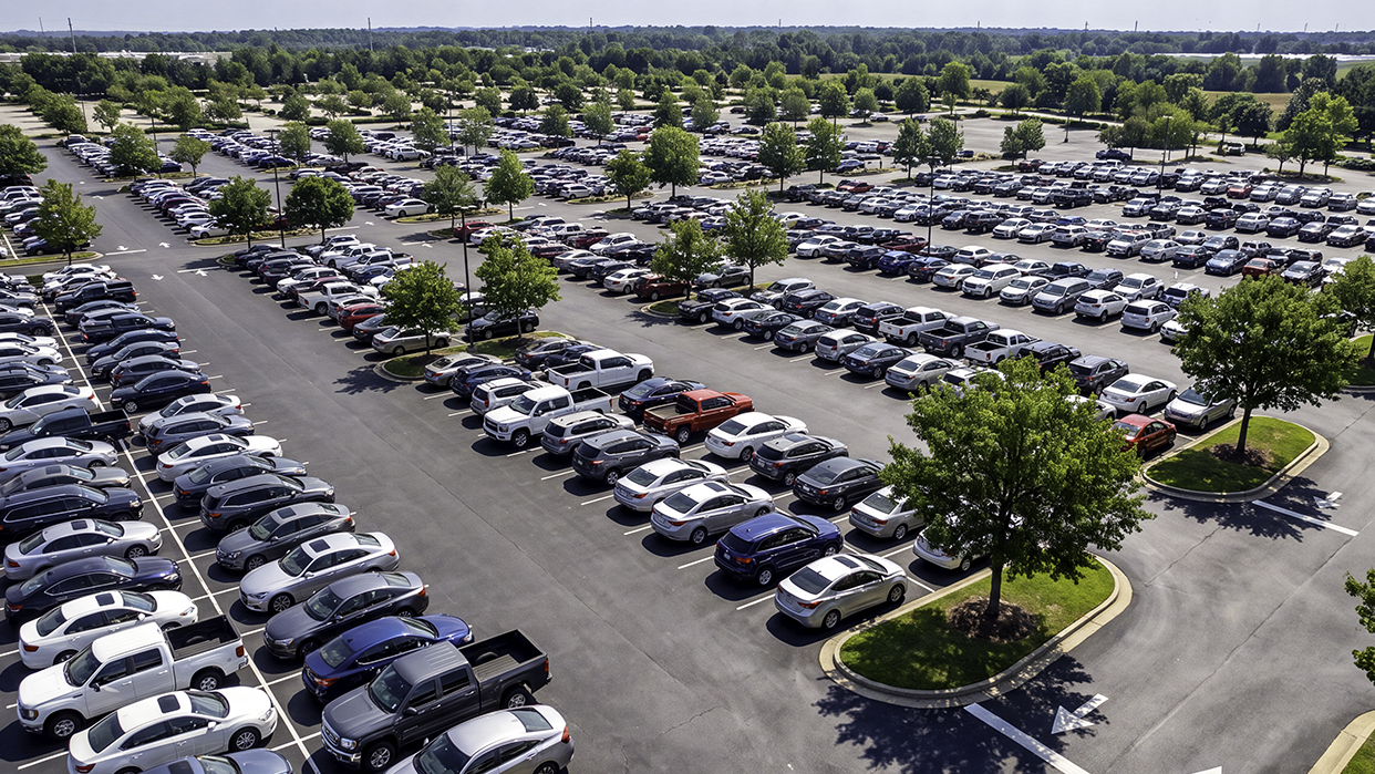 Aerial view of a large parking lot filled with cars, showing why a vehicle locator helps you find your car