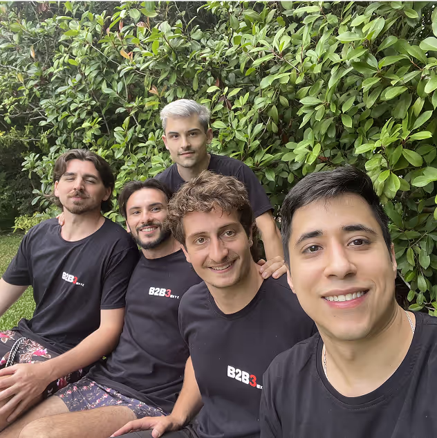B2B3 team members taking a selfie outdoors against lush green foliage, wearing matching branded t-shirts and enjoying team bonding time
