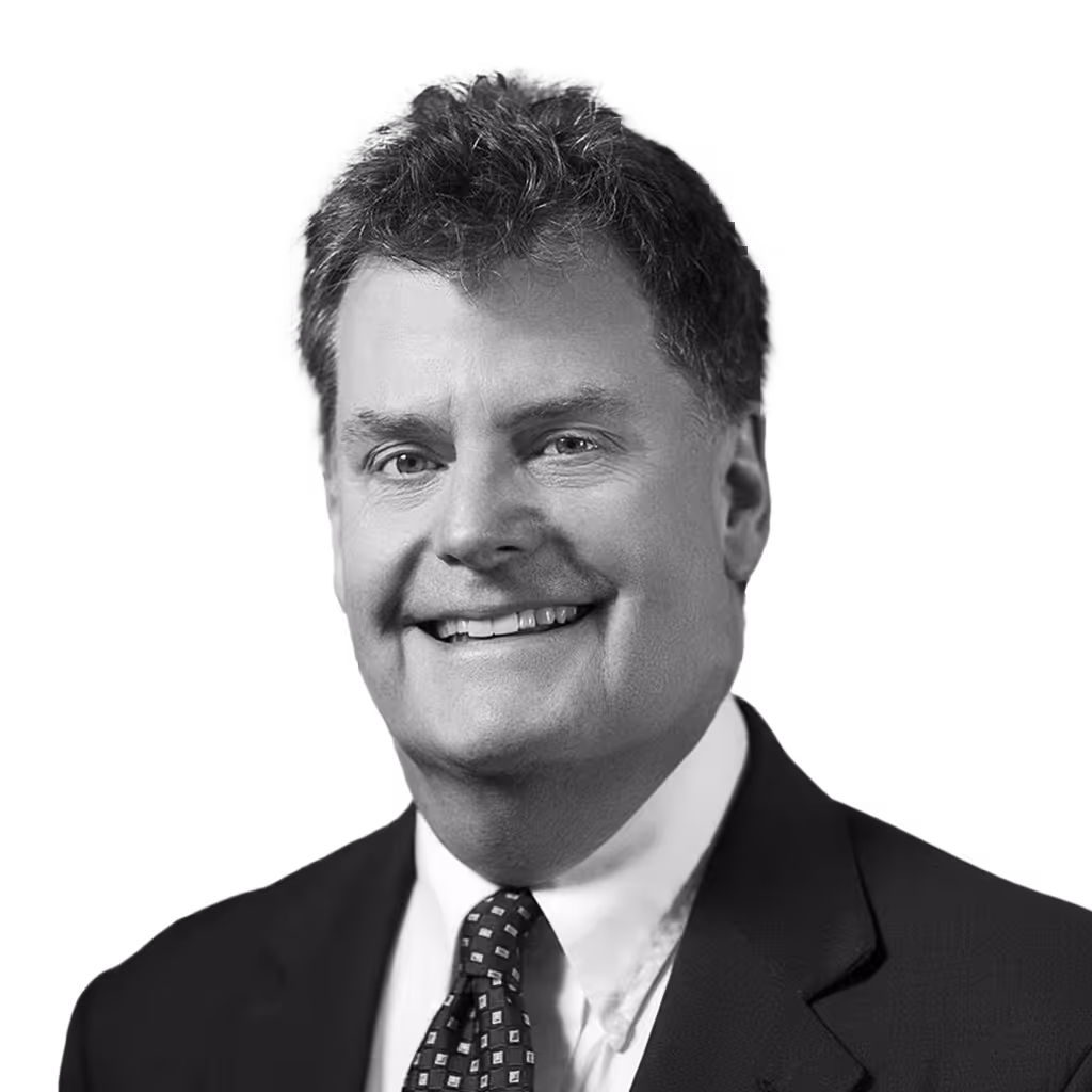 Smiling middle-aged man with curly hair wearing a suit and patterned tie.