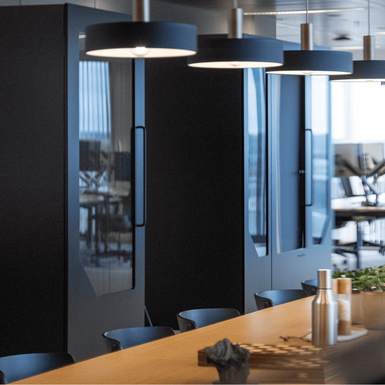 Black soundproof office pods with modern lighting for private calls and focused work in coworking space