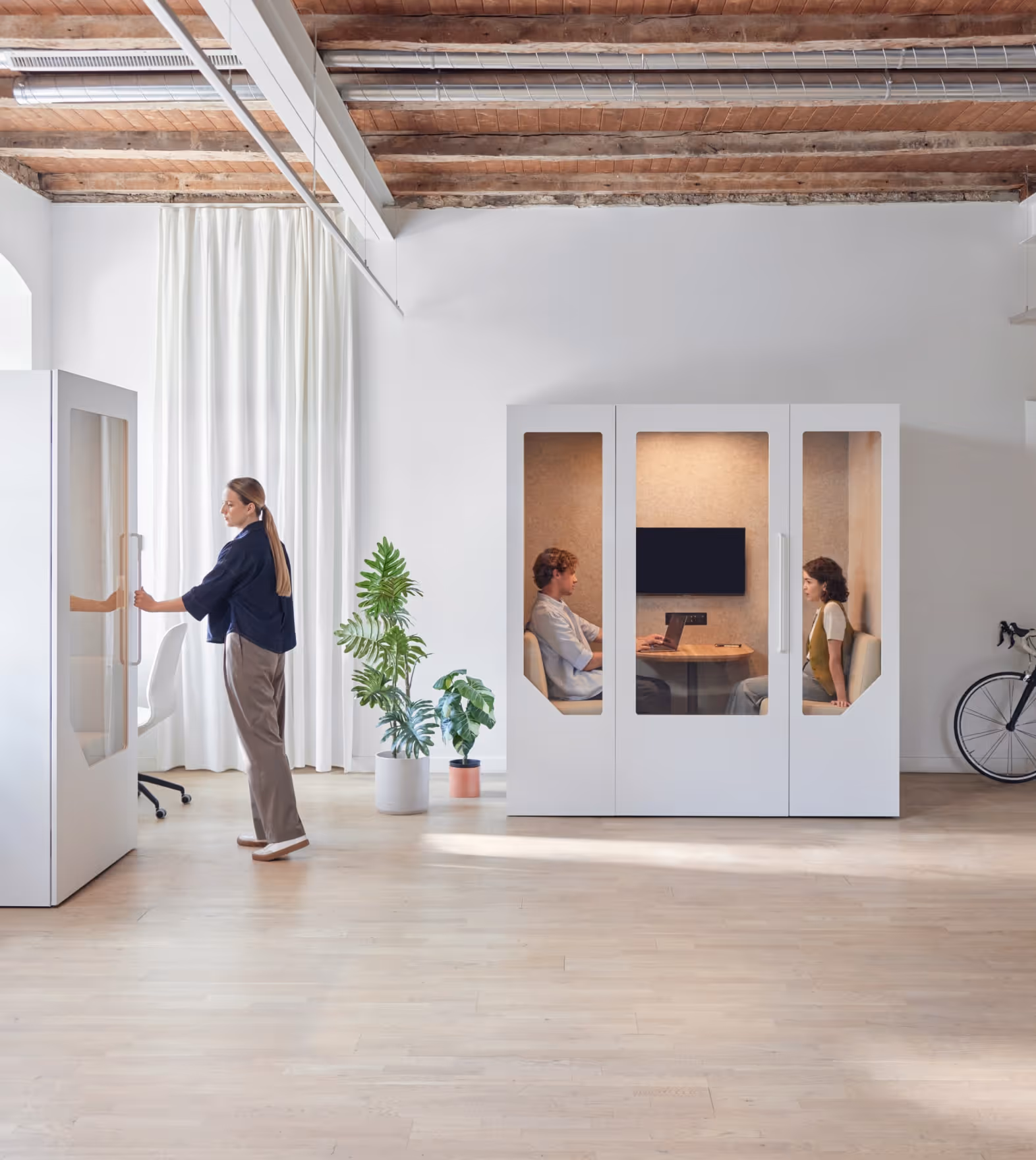 Profis verwenden die schalldichten Bürokapseln von Persy Booth für private Anrufe und Besprechungen in einem modernen Arbeitsbereich.