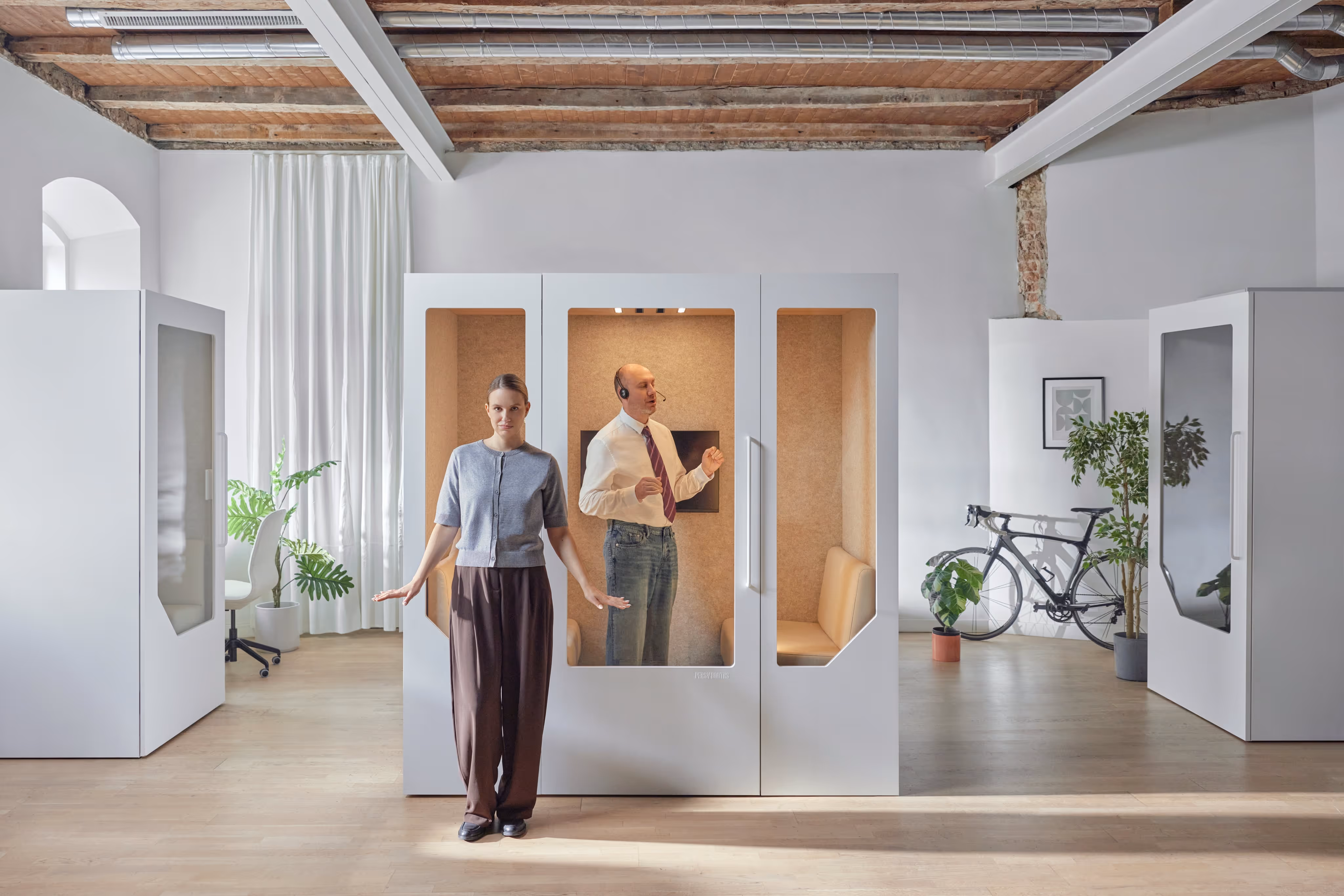 Schalldichter Pod von Persy Booth demonstriert Stille, während eine Person draußen und eine weitere Person drinnen telefoniert