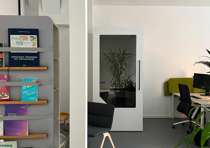 Persy Booths team standing in front of a bright yellow soundproof office pod