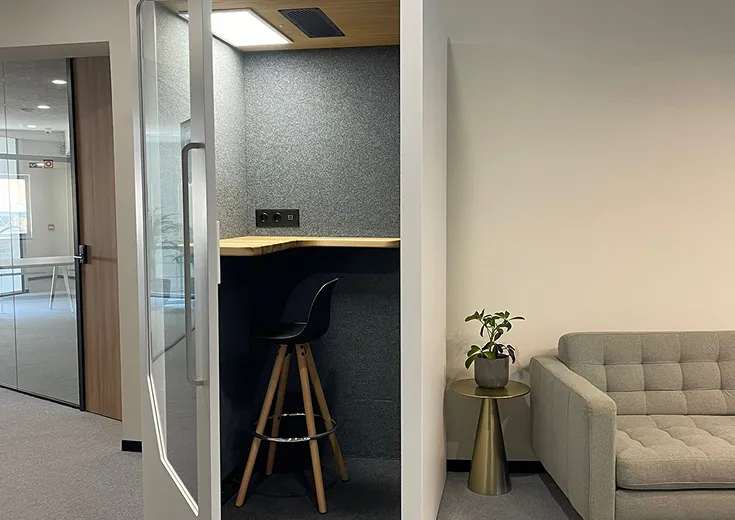 Persy Booths team standing in front of a bright yellow soundproof office pod