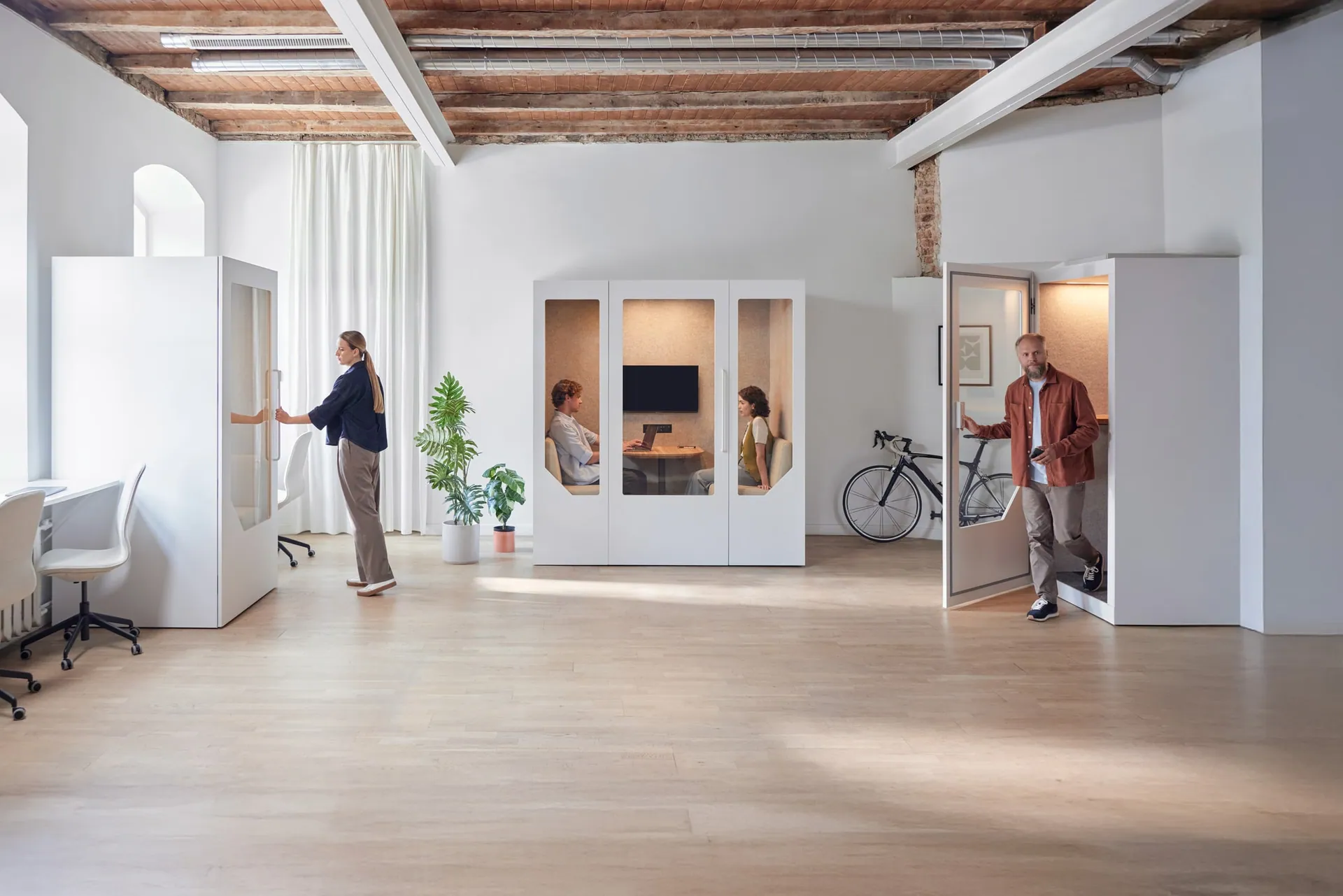 Professionals using Persy Booths soundproof office pods for private calls and meetings in a modern workspace.