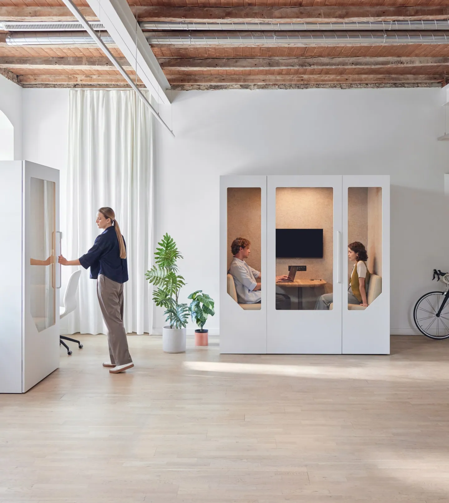 Professionals using Persy Booths soundproof office pods for private calls and meetings in a modern workspace.