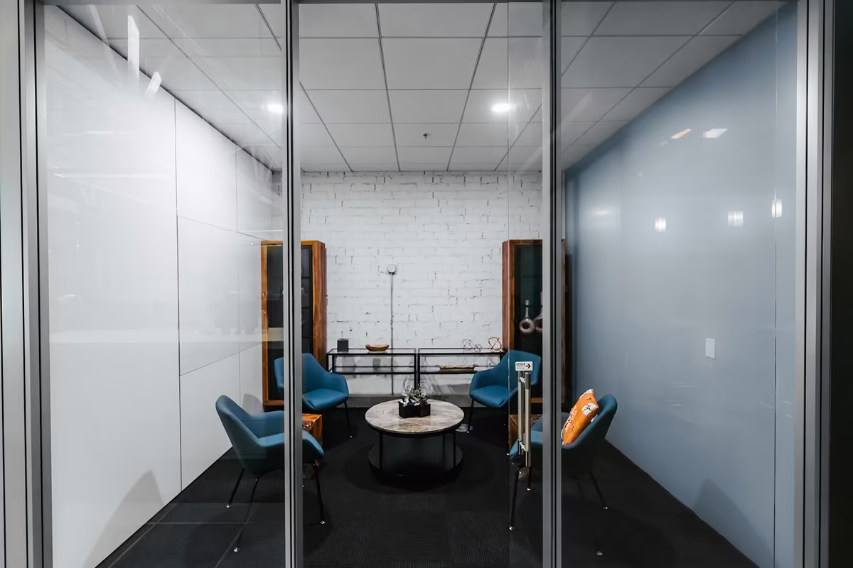 Enclosed office meeting room with glass partitions designed to isolate sound from the surrounding workspace