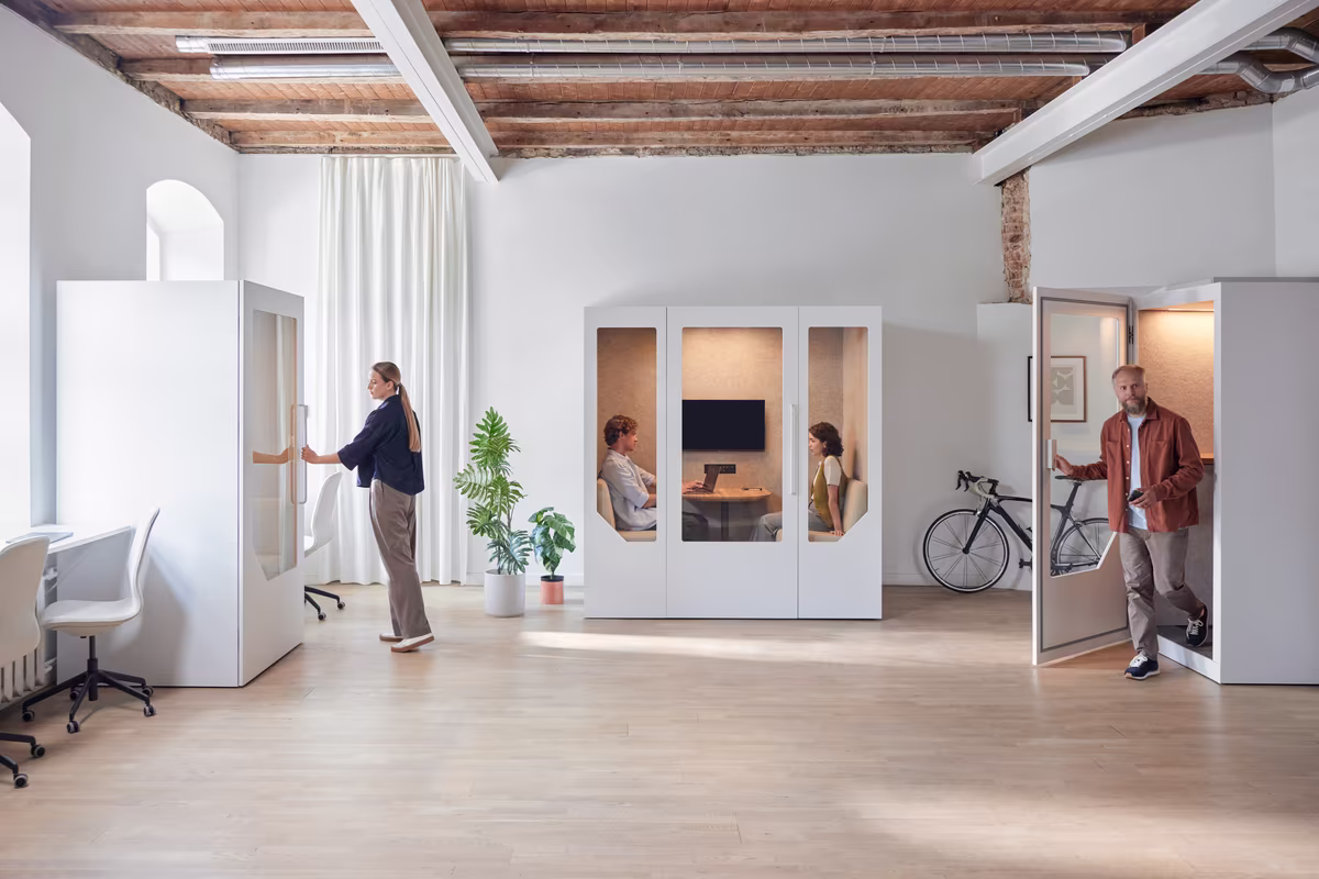 Employee working on a laptop inside an acoustic office booth designed for focused work