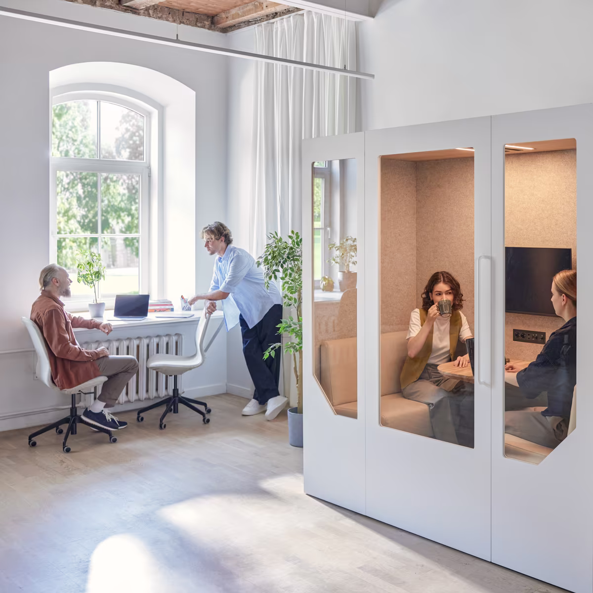 Small team collaborating inside an office meeting pod