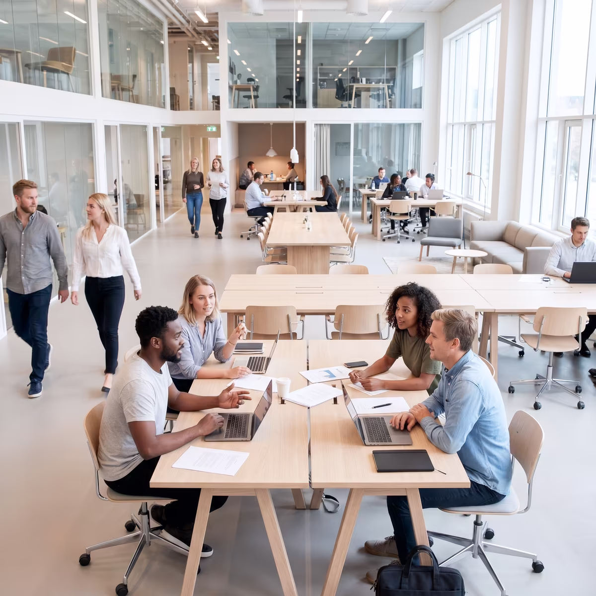 Teams working and talking in a busy open-plan office environment