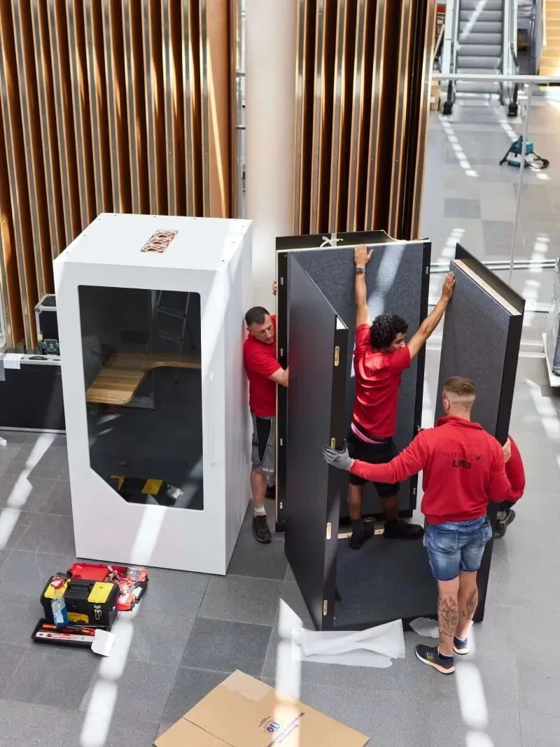 Local installation team assembling a Persy office booth