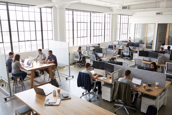 Modern open office layout with collaboration areas and individual workstations in natural daylight