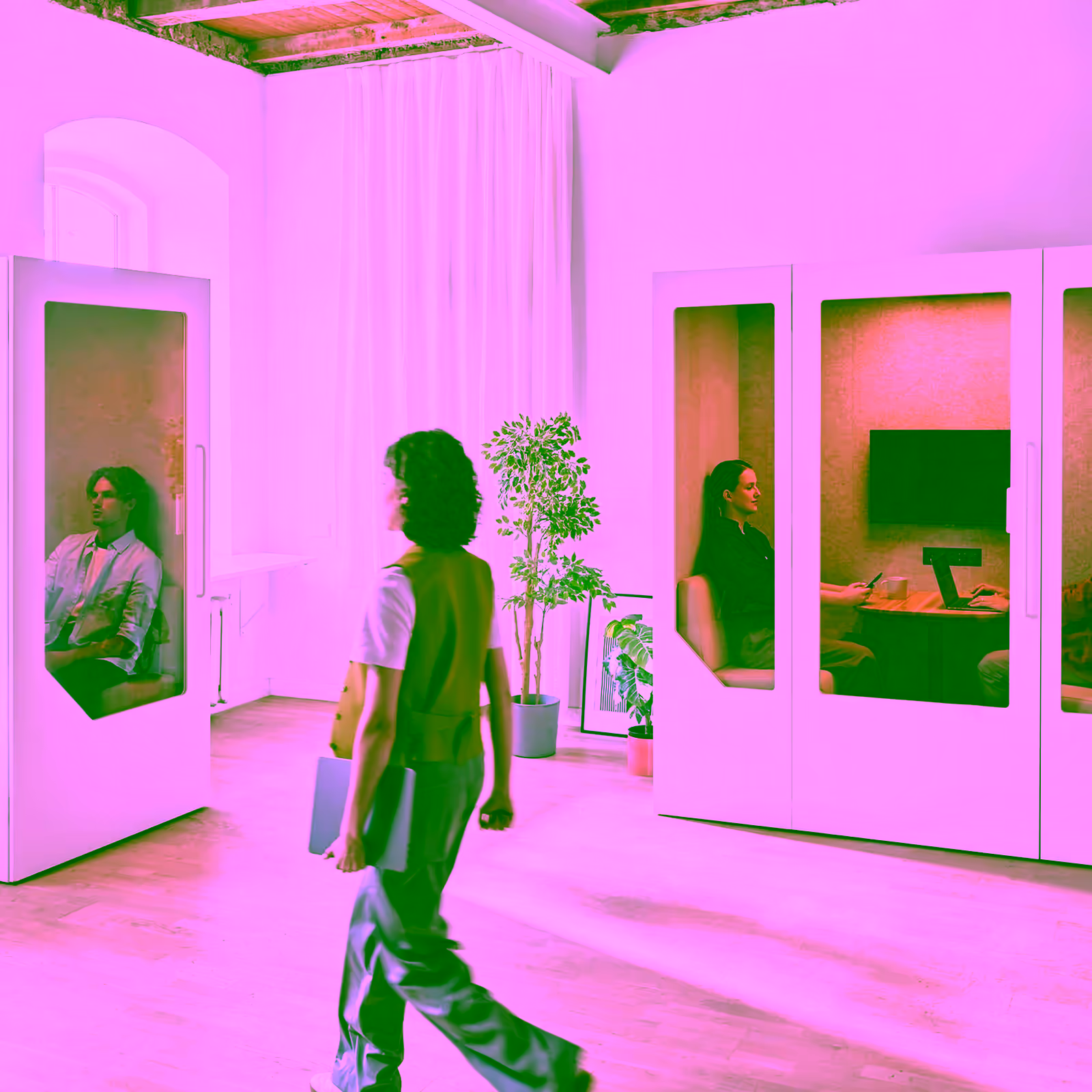 Employees using office pods and walking through a bright open plan hybrid workspace