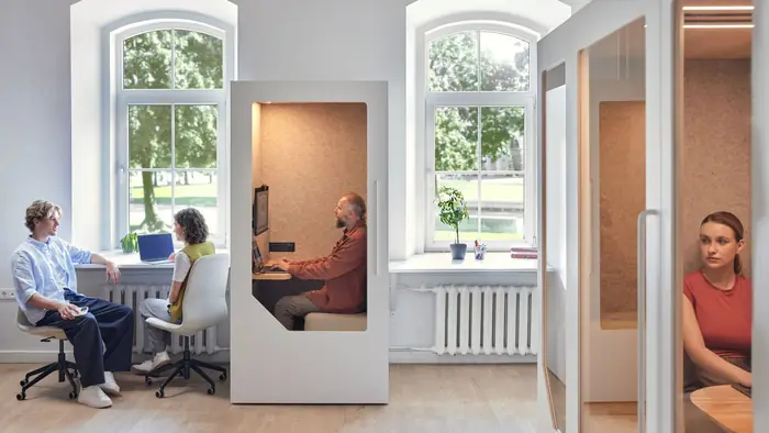 Person working in a soundproof office pod in a modern open-plan office
