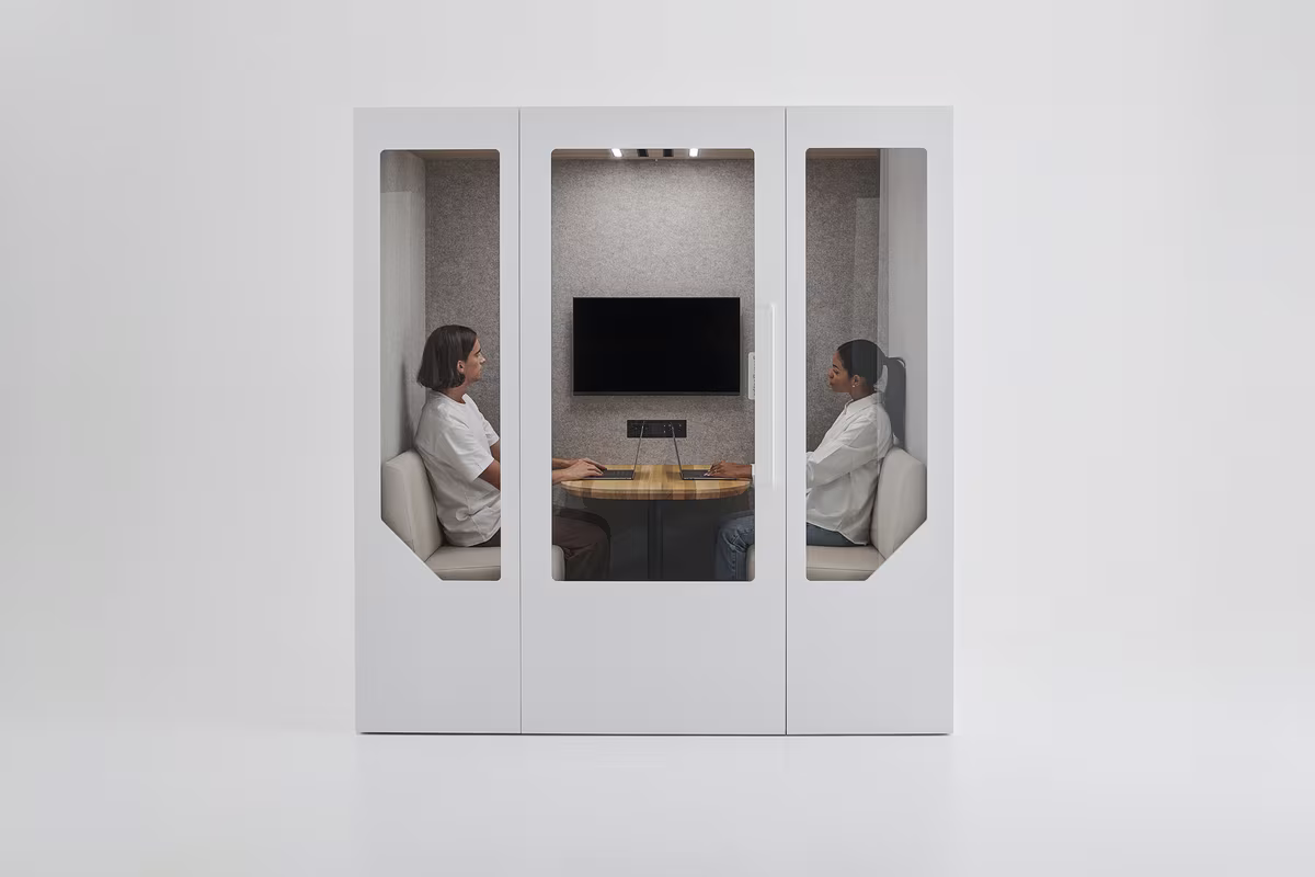 Two people in a meeting inside a soundproof office pod with a screen