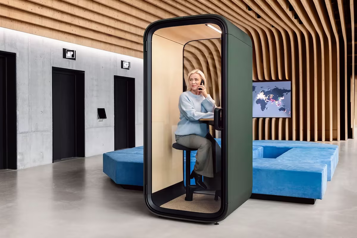 Woman taking a phone call inside a Framery One office phone booth