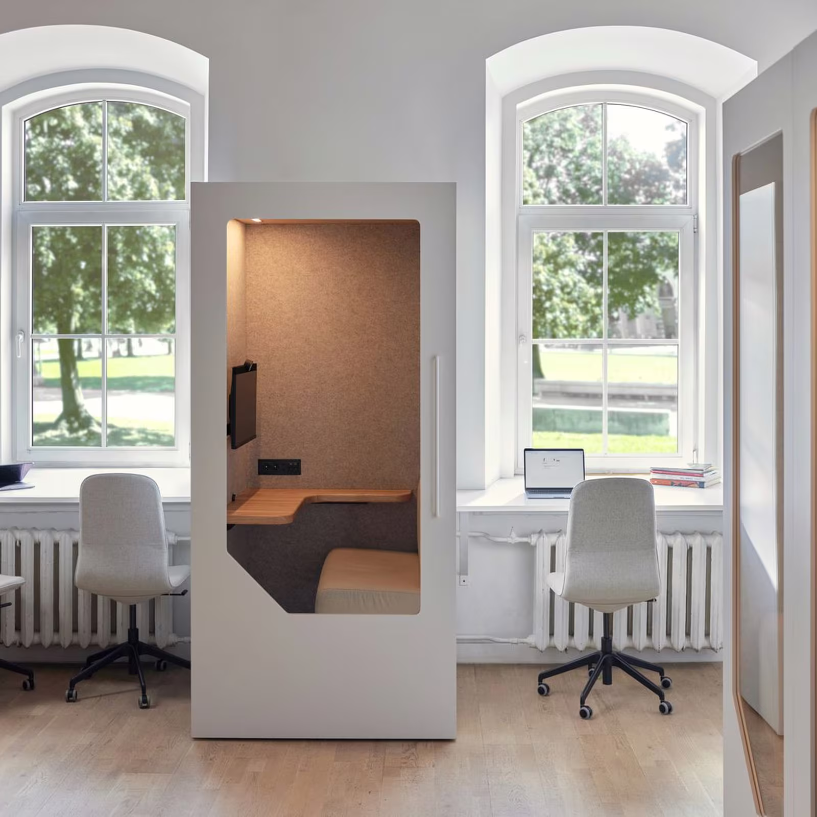 Open Persy work booth beside desks in a bright office