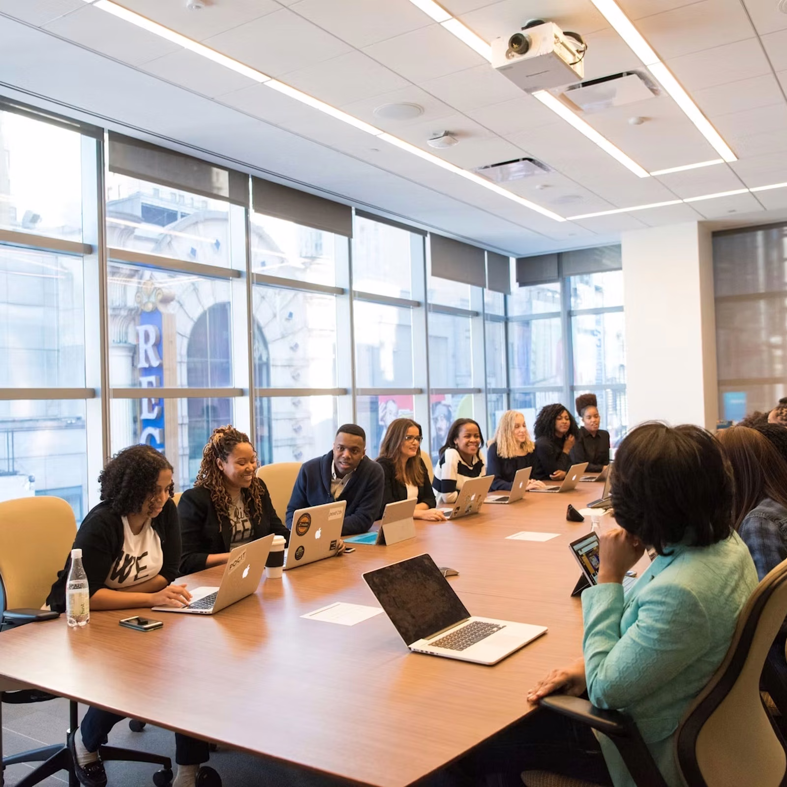 Team of professionals collaborating around a large conference table in a bright modern meeting room.
