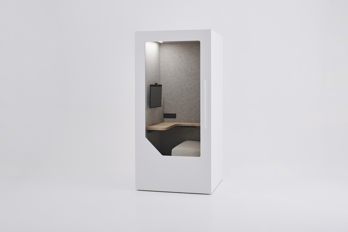 White Persy Work acoustic office booth with grey felt interior, built-in desk, sofa seat, power outlets, and a wall-mounted monitor.