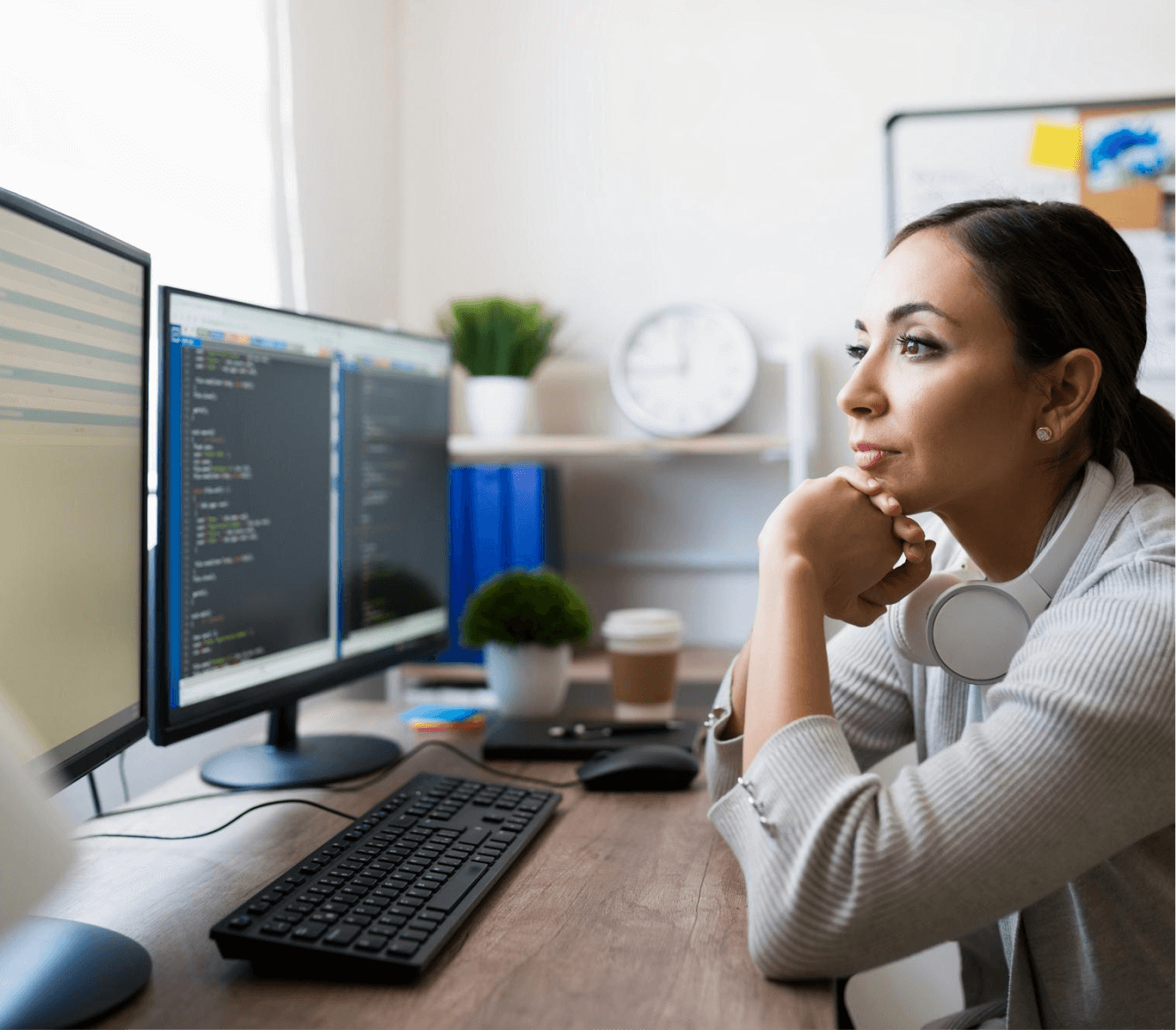 Woman coding at dual monitors.