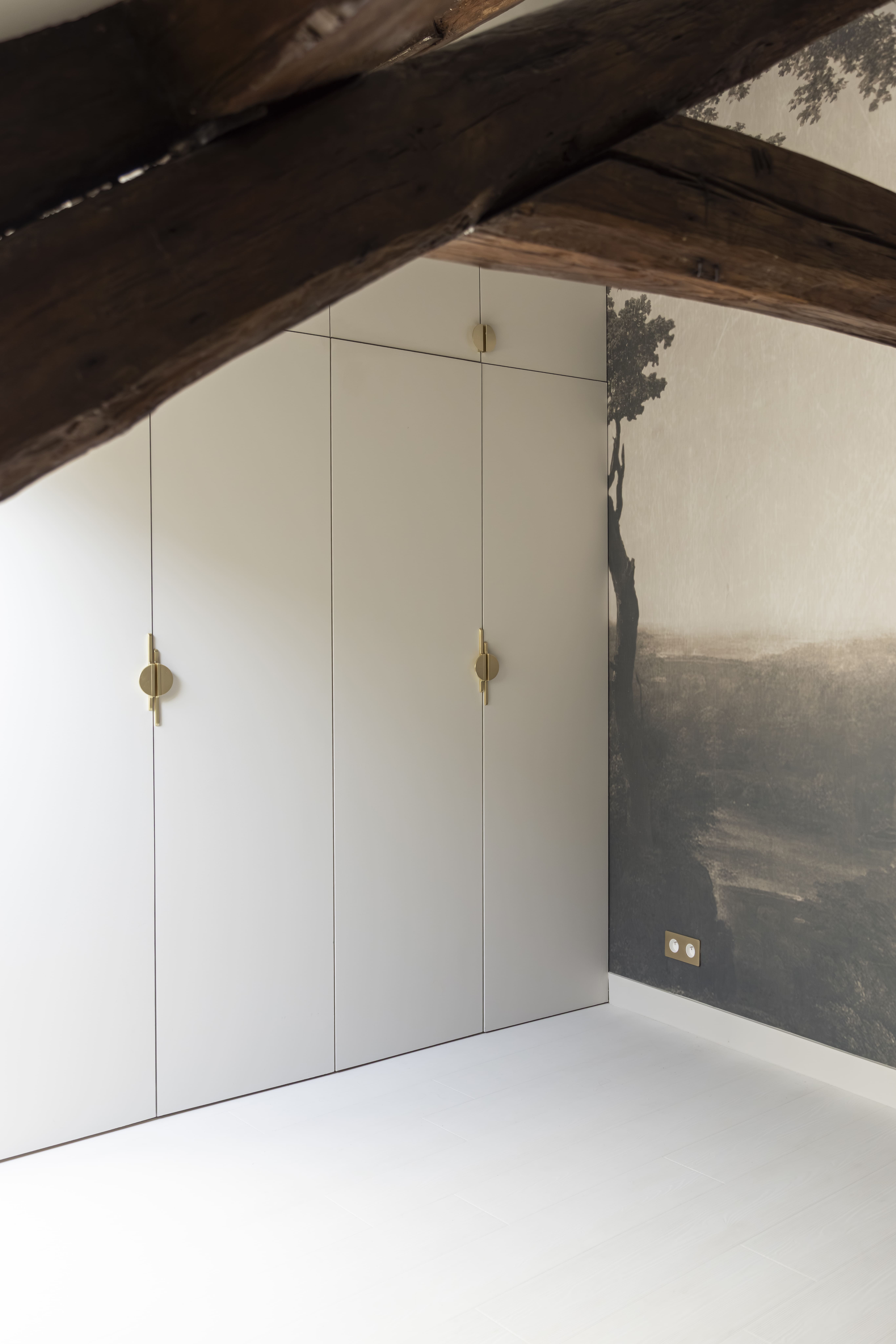 Rénovation d’un espace sous les toits à Paris avec rangements sur mesure et murs blancs