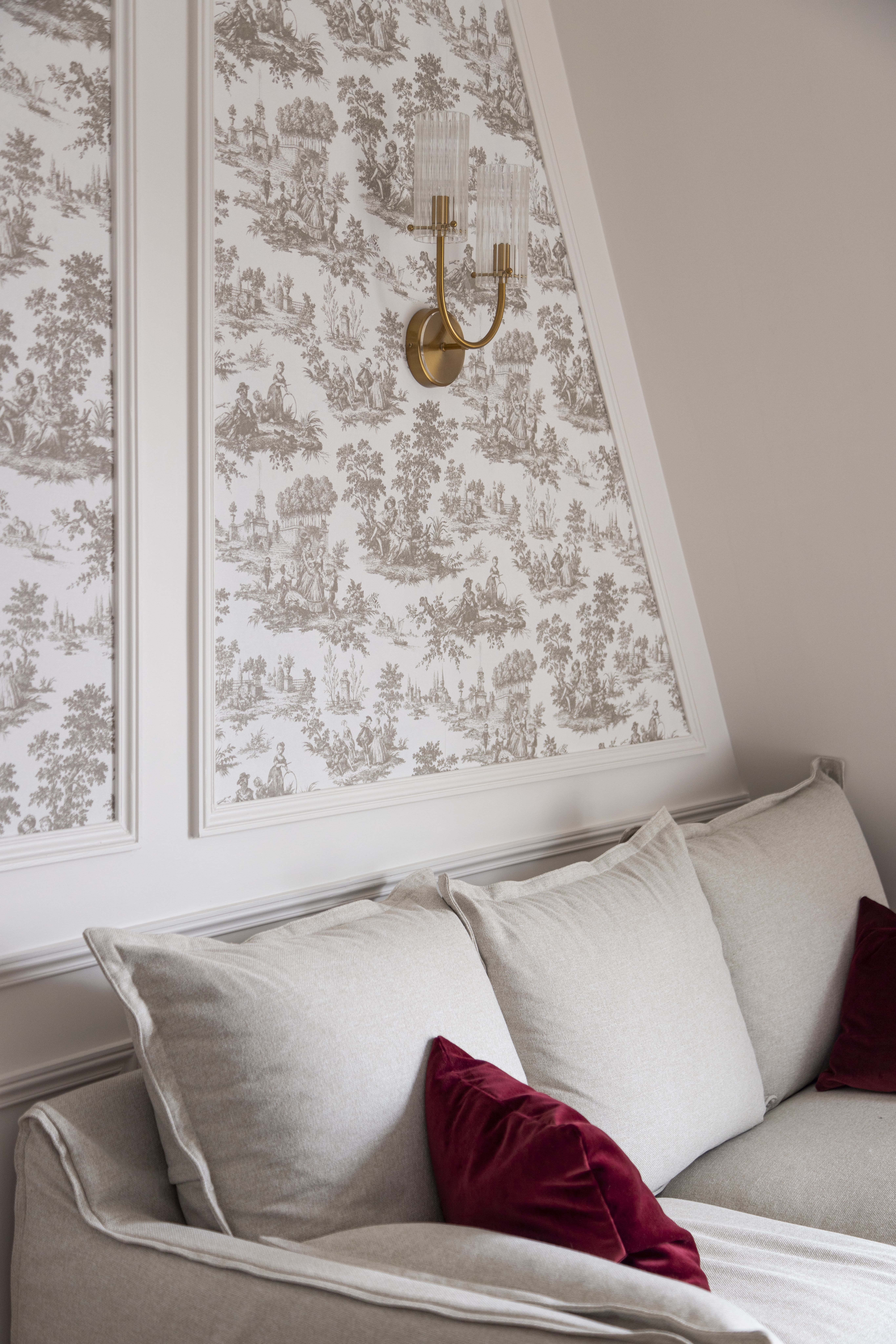 Salon clair avec papier peint toile de Jouy et coussins bordeaux – rénovation d’appartement parisien