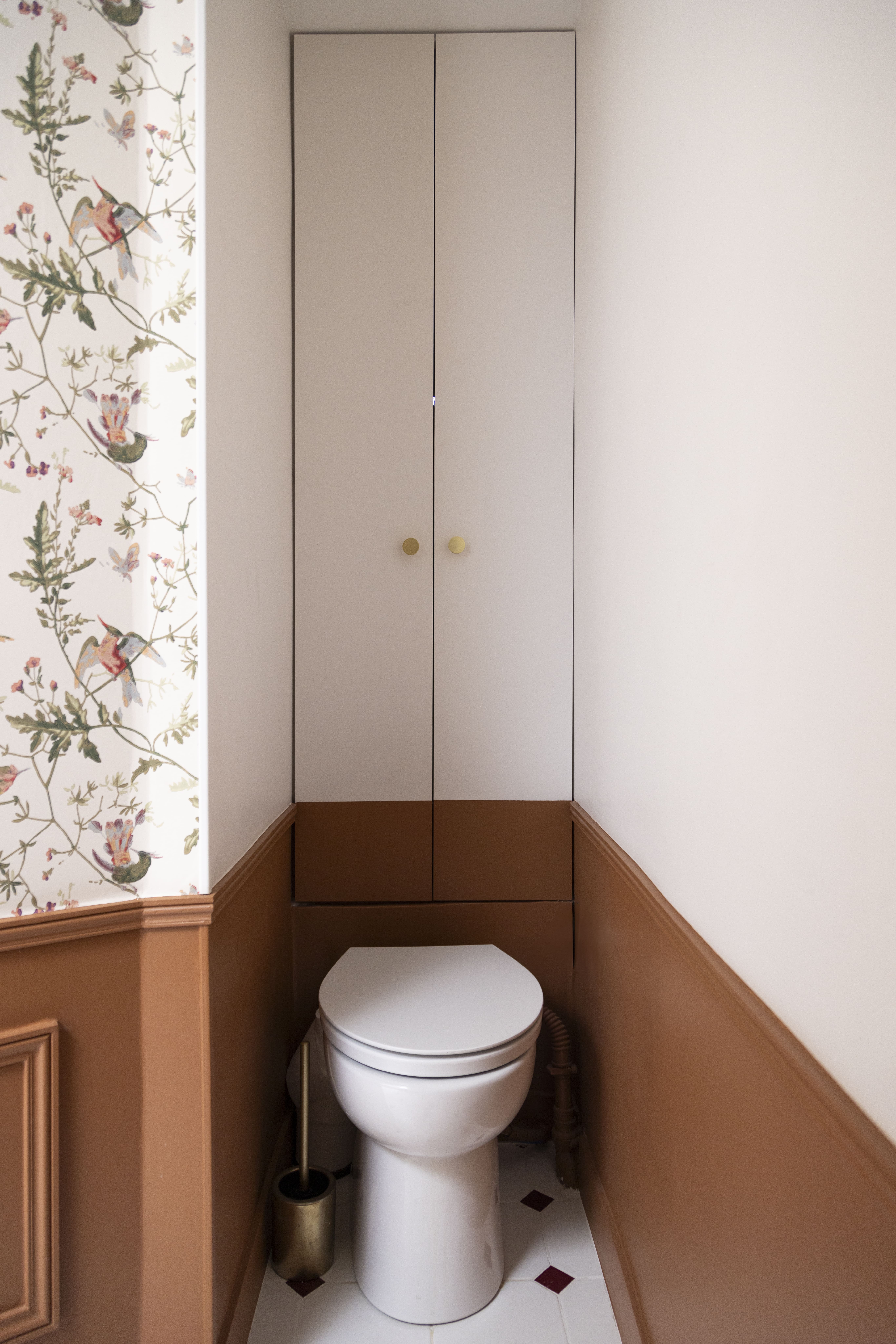 Toilettes rénovées avec papier peint floral et boiseries brunes – design d’intérieur