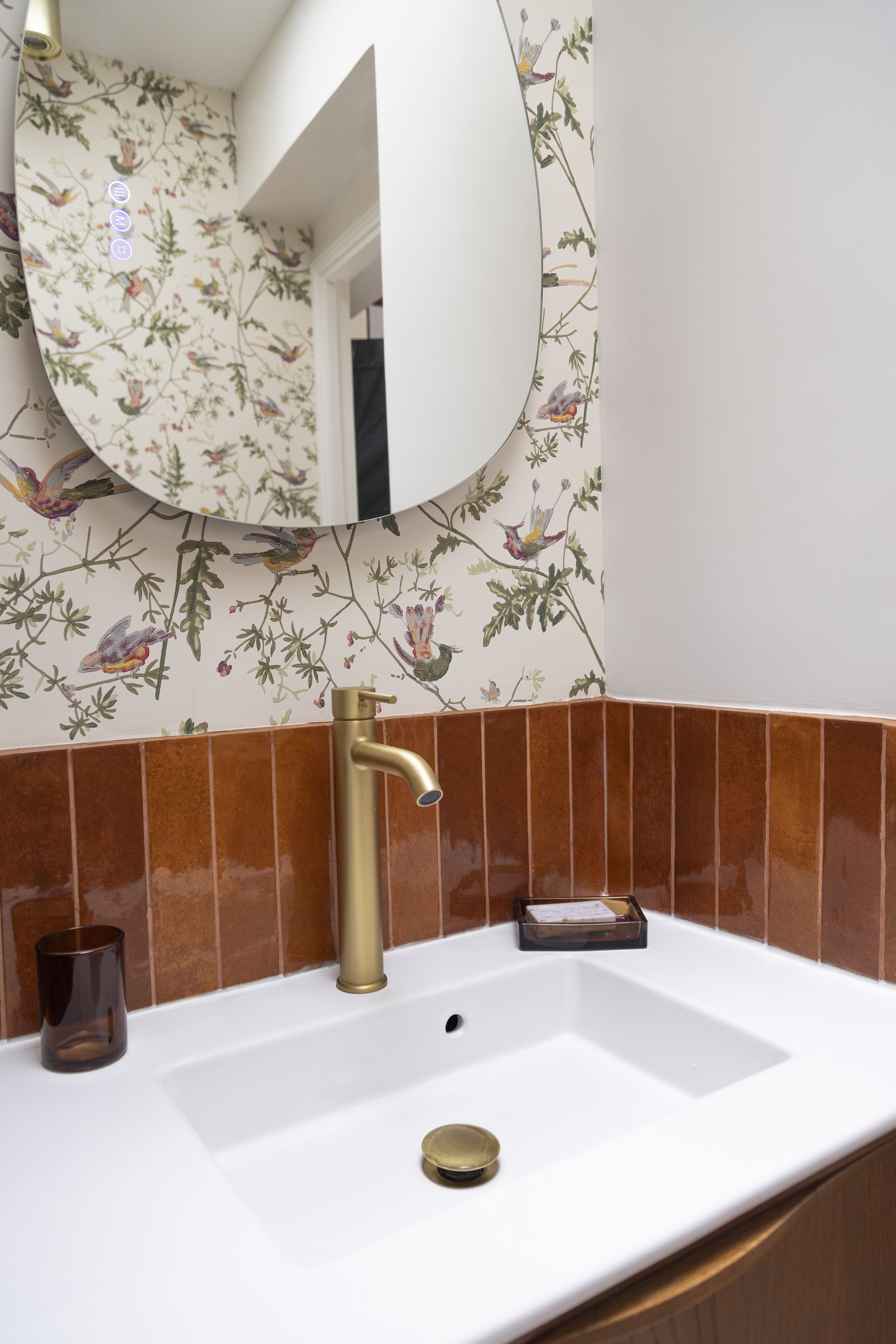 Vasque blanche moderne et robinet doré sur fond de papier peint à fleurs