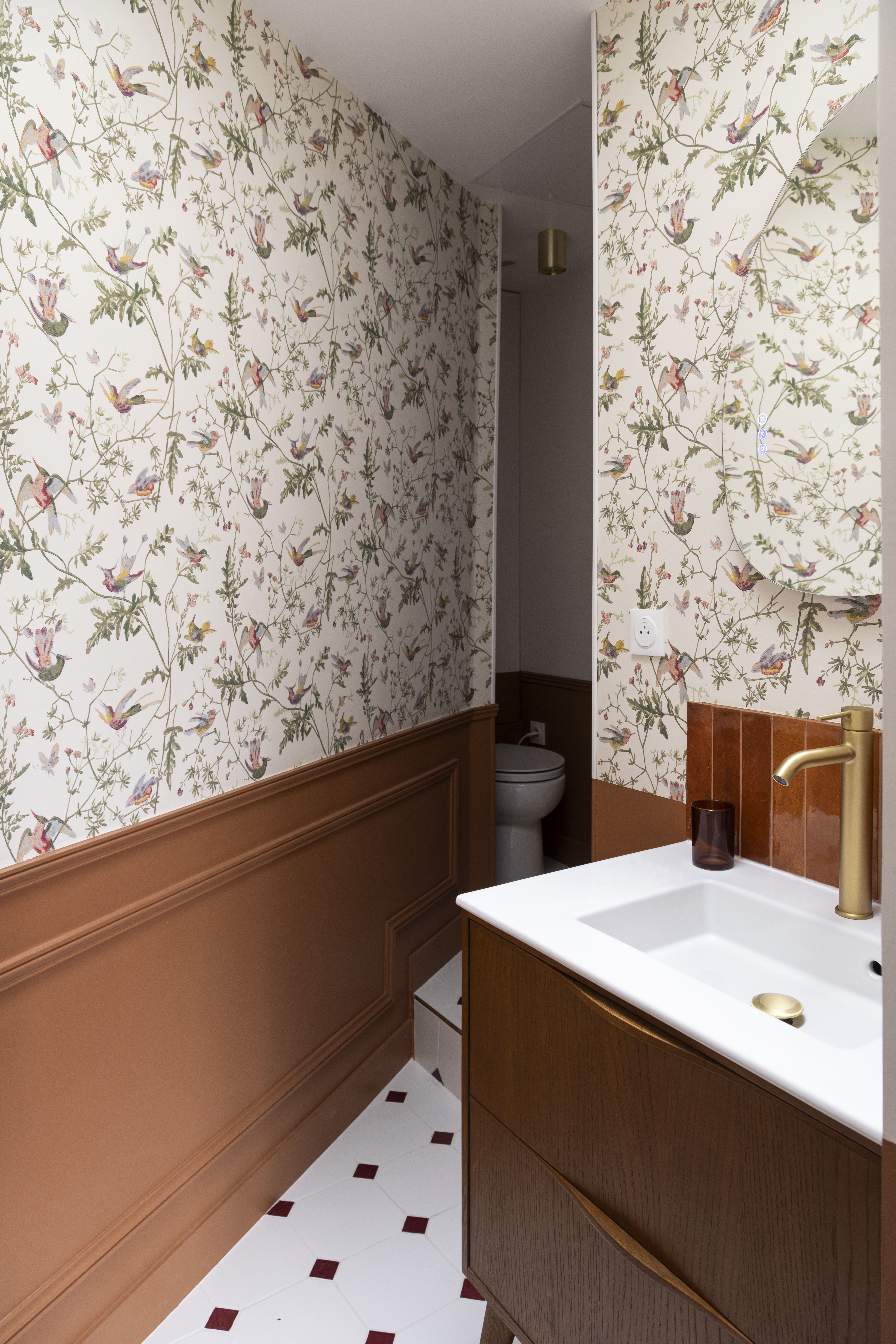 Salle de bain lumineuse au style vintage chic avec zellige marron et motifs floraux