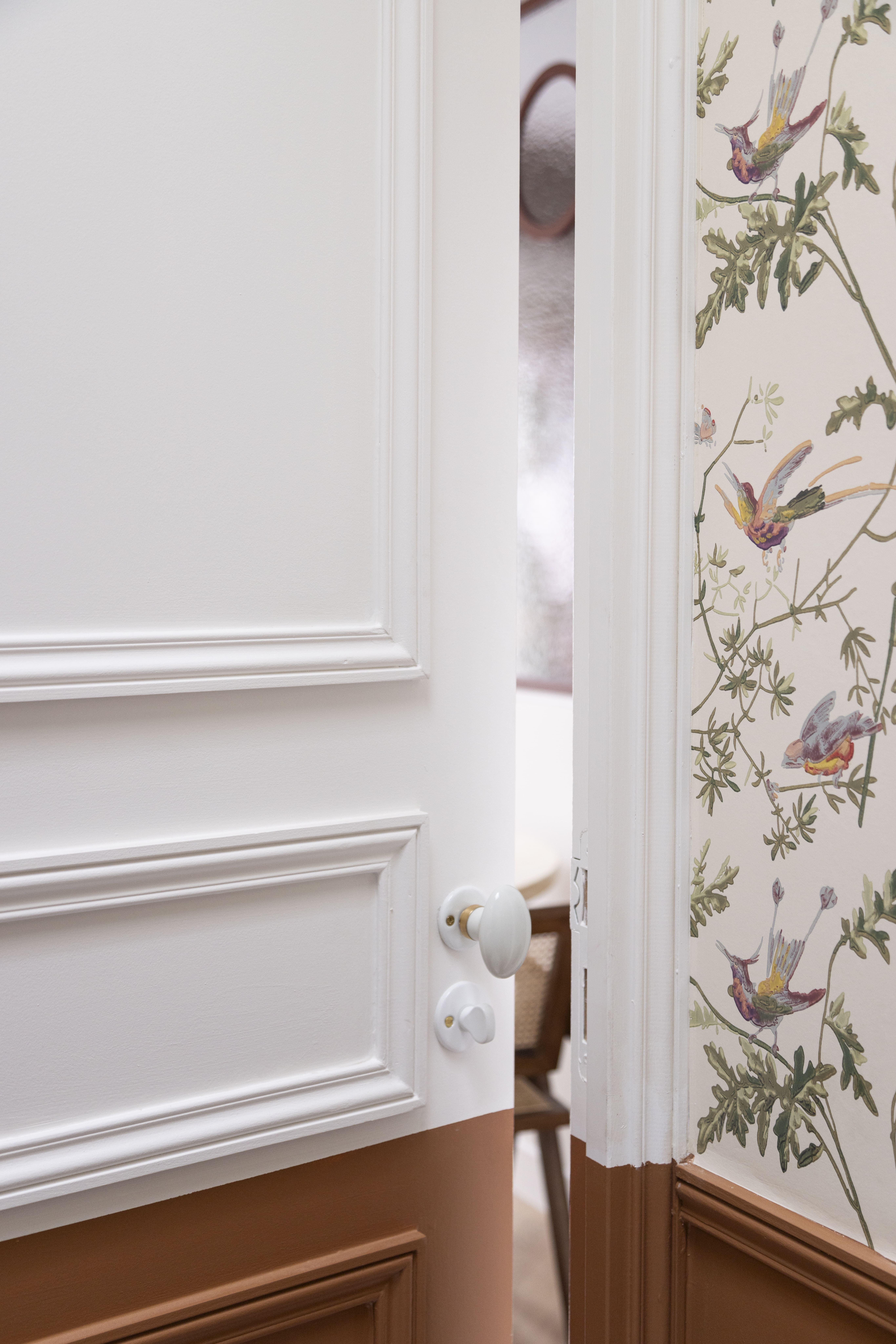 Couloir parisien avec moulures blanches et papier peint floral – rénovation élégante