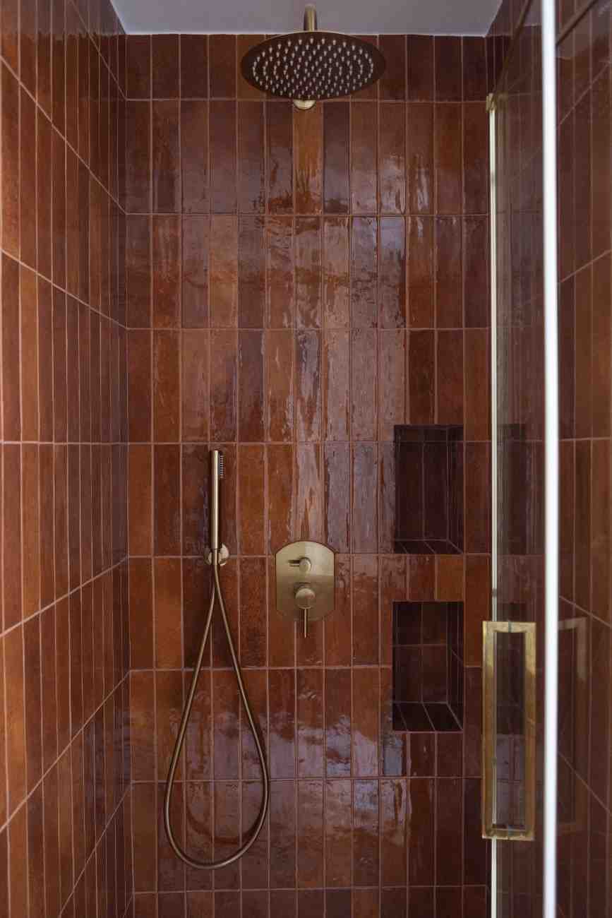 Douche italienne en zellige brun avec robinetterie dorée – rénovation salle de bain