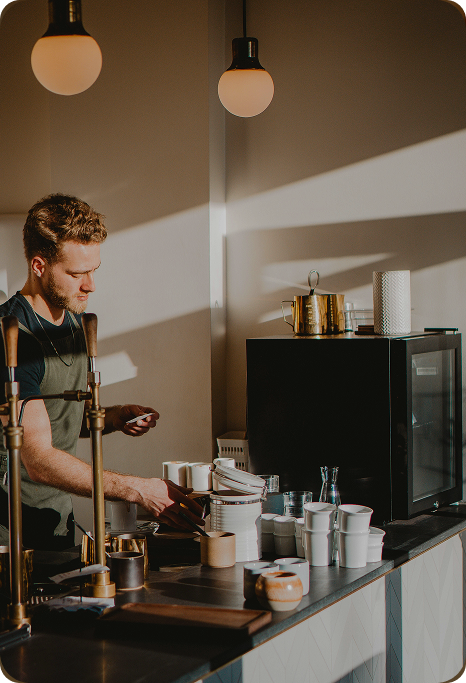 A male barista in a coffee shop.
