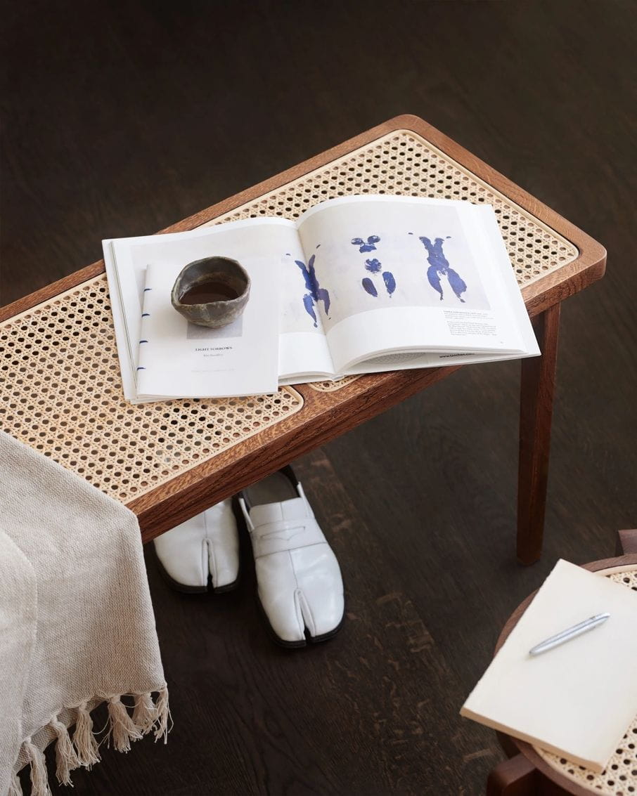 A table with a book and a cup on itDescription automatically generated