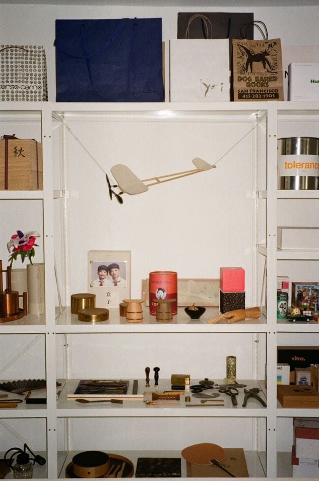 A shelf with objects and a model airplaneDescription automatically generated