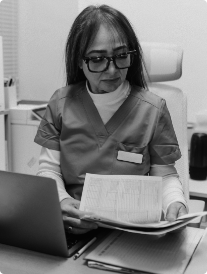 Clinician reviewing paper records at a computer