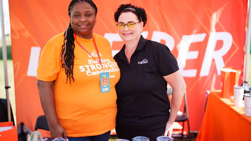 Two LFT Fiber team members smiling at an event booth.