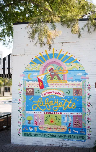 Colorful mural promoting Downtown Lafayette with symbols of local culture and fun.