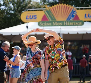 Couple dancing in front of the LFT Fiber sponsored tent at a festival.